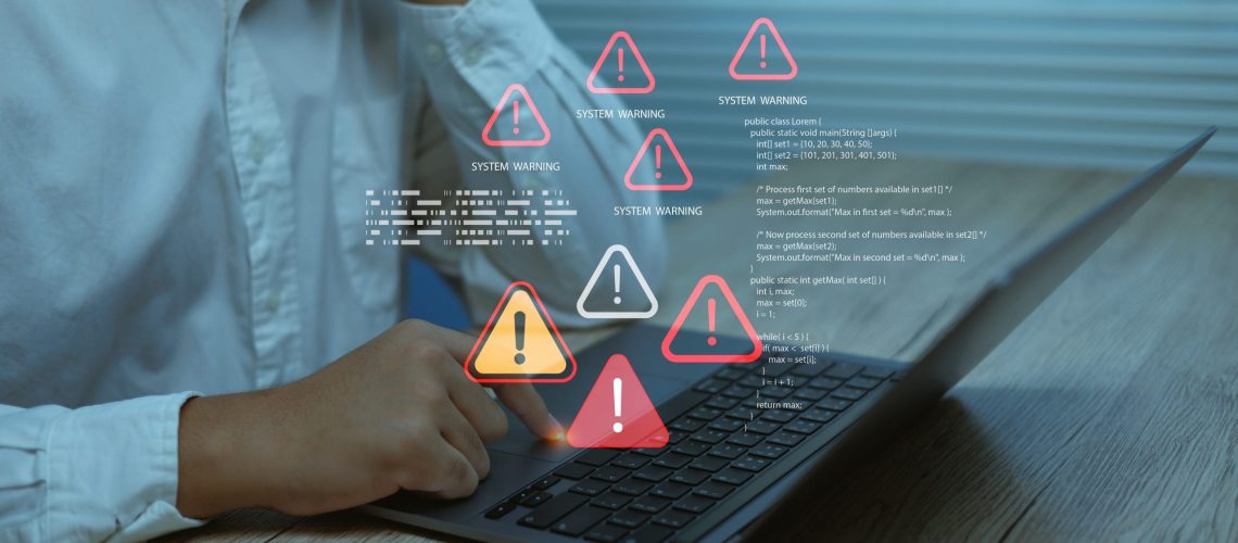 Business user facing system warning alerts error icons on laptop screen, symbolizing cybersecurity risk, software failure, data protection issues and digital technology problems.