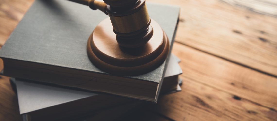 law book with a wooden judges gavel on table