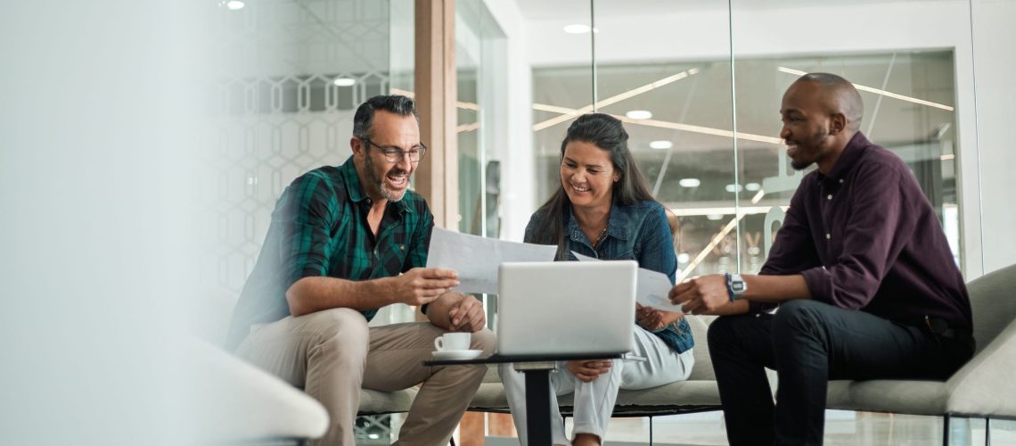Casual meeting of smiling diverse business team analyzing financial data